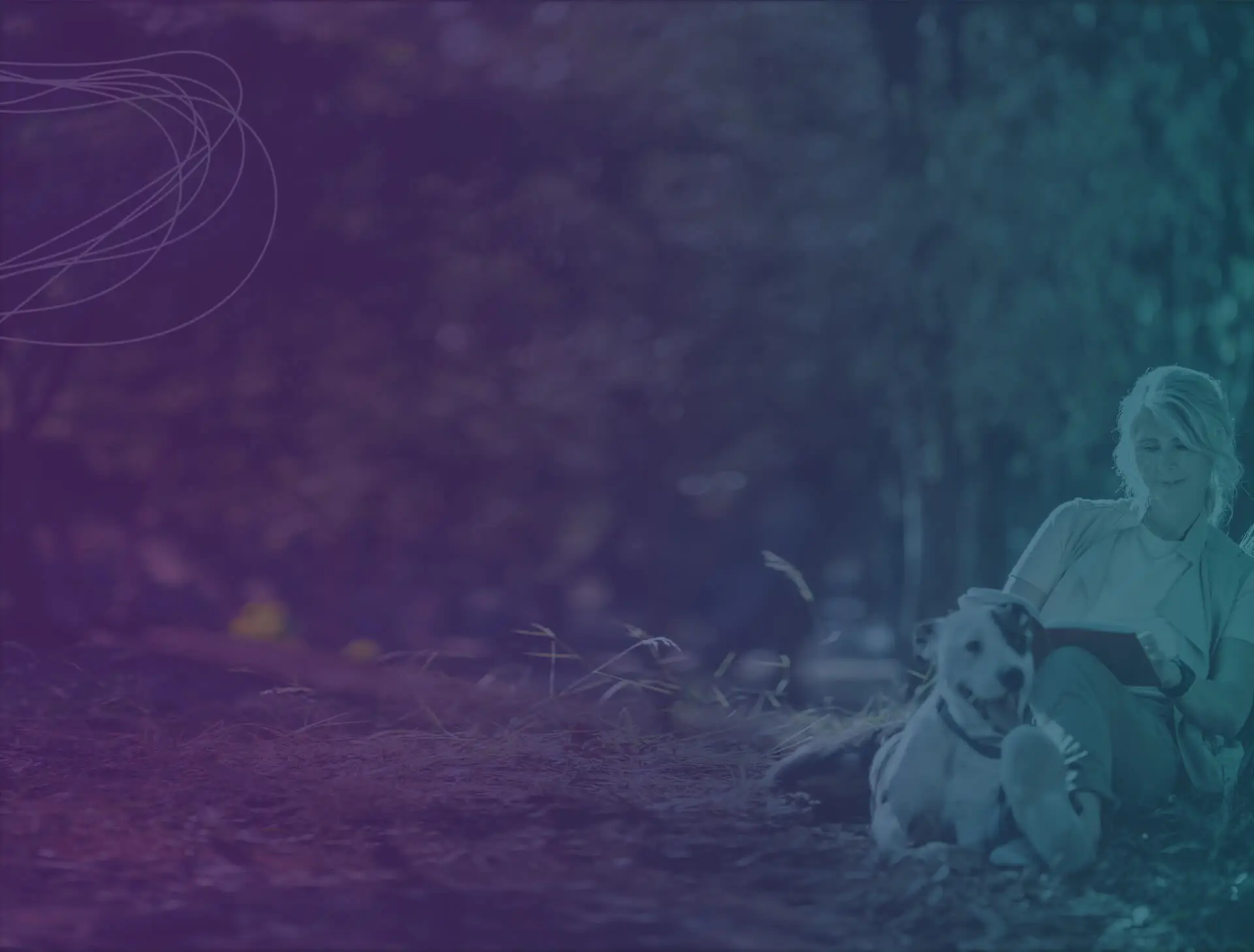 woman reading a book next to her dog